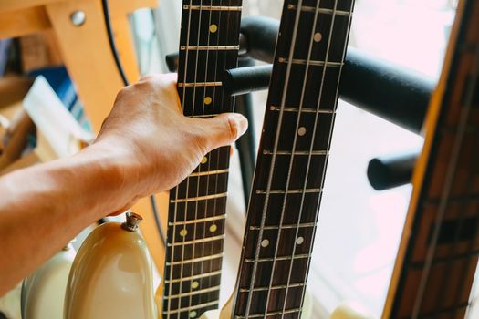 close up Image of Hand picking up guitar
