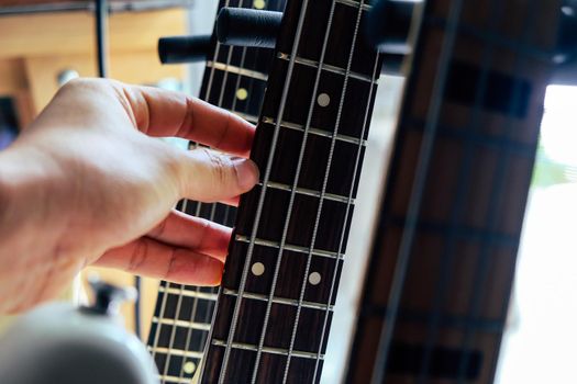close up Image of Hand picking up guitar
