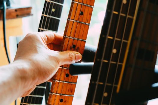 close up Image of Hand picking up guitar