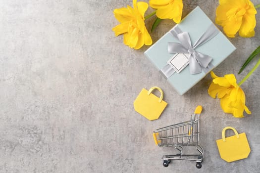 Concept of Mother's day holiday gift shopping greeting design with yellow tulip flower bouquet on gray background