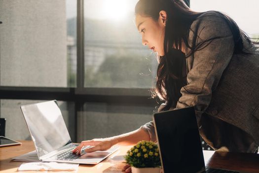 Attractive asian woman usiing laptop computer at her office.