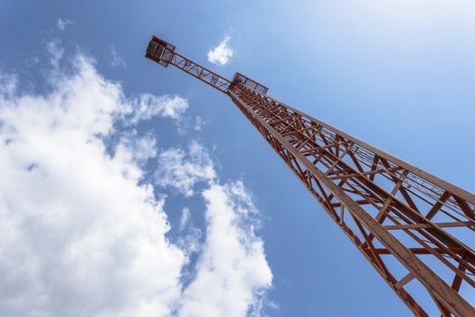 Construction crane against blue sky, bottom view.