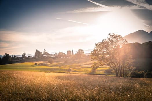 Scenic sunset view over meadow, hills and mountains.