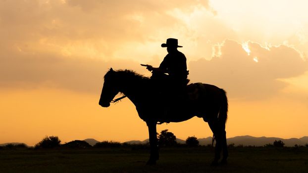 cowboy on horseback against a beautiful sunset, cowboy and horse at first light,mountain, river and lifestyle with natural light background	
