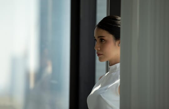 Side view of businesswoman looking through window.