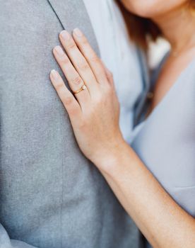 Bride put her hand on the chest of groom, hugging him. High quality photo