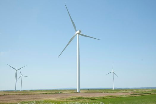 View of turbines on Tantramar Marsh with windmills passing from the highway 