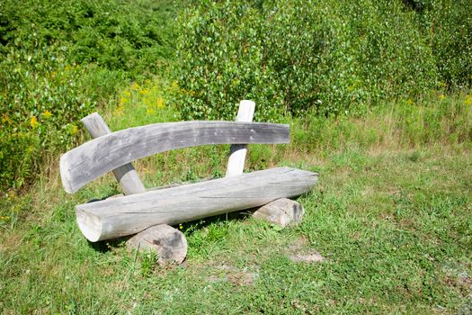  a gorgeous grey wood bench sitting among the grass outside on a summer day 