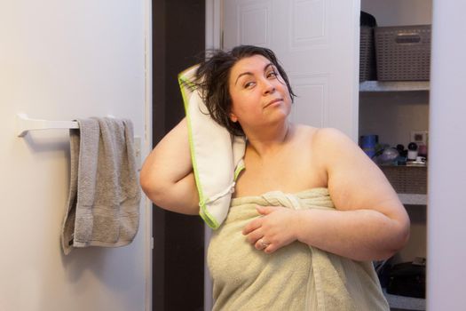  Curvy woman checks her reflection in the mirror as she starts her post-shower routine. 