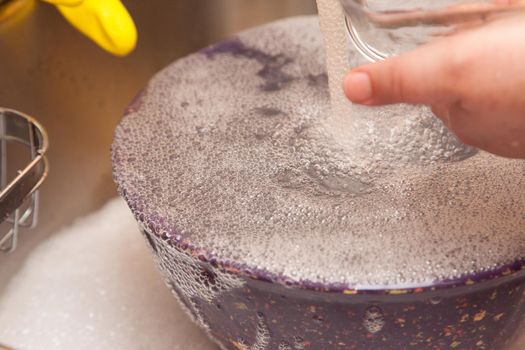 A bowl being washed bubbles up with dish liquid