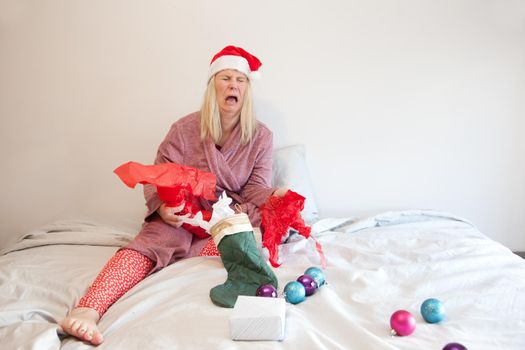 an exhausted woman isn't happy with her presents so cries in bed on christmas morning 