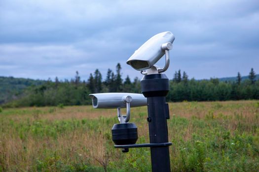 Two silver binocular or viewing spots at a look off site 