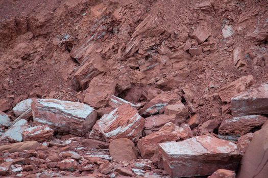 part of a cliffside has come loose and fallen to the ground leaving huge rocks 