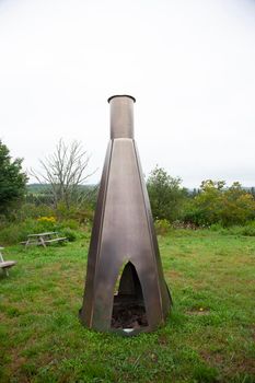 unique industrial outdoor chimney or cooking space with park benches 