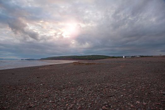 August 18, 2019 - Five Islands, Nova Sctia - gorgeous beach with heavenly sunset with hues of blue and purple in nova scotia with lighthouse 