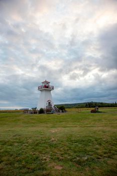 August 18, 2019 - Economy, Nova Scotia - white and red lighthouse against a cliffside in rural Nova Scotia on a cloudy evening in summer 