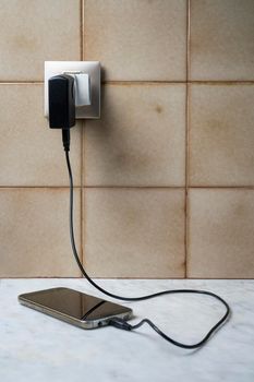 a mobile phone connected to a phug for charging 