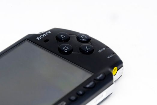 Rome, Italy, April 9th 2021: Side view of a Sony PlayStation Portable (PSP). PSP is a handheld game console developed and marketed by Sony. Mobile entertainment. Focus on the Sony logo and the buttons