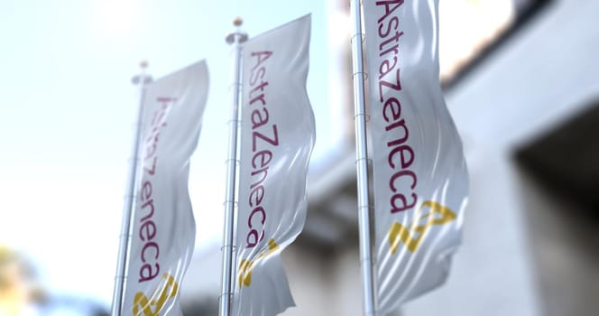London, UK, February 26, 2021: Three vertical white flags with the Astrazeneca logo are flapping. Astrazeneca is a British pharmaceutical company that has produced a vaccine for the Covid-19 coronavirus