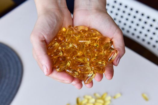 Hands holding fish oil Omega-3 capsules. Medical healthcare, healthy nutrition supplements concept. Vitamin tablets.