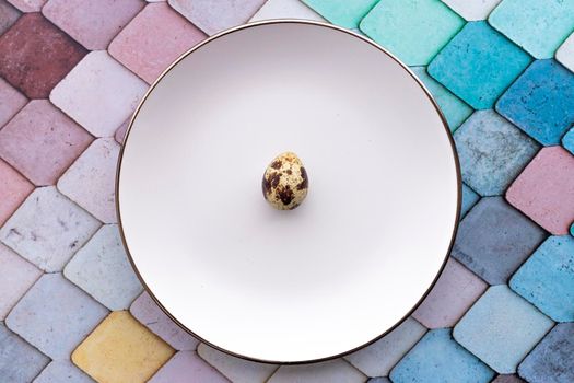 Quail eggs inside a decorative plate and on a background