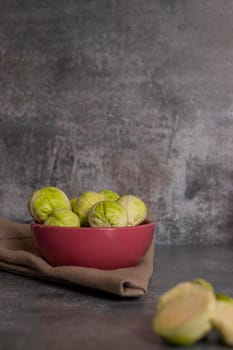 Fresh brussels sprouts served in bowl and with marbled gray background
