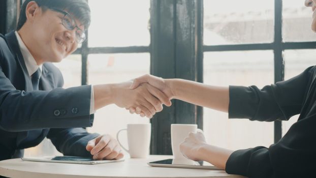 Happy two young businessman and woman shaking hands after successful meeting or negotiation with digital tablet sitting on desk cafe, Businesspeople discussion and smile lunch