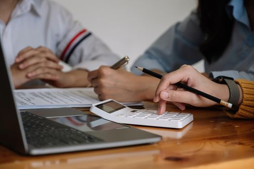 Business team colleagues discussing and analysis working Financial investment on calculator with calculate on tablet Analyze market growth on financial document data graph.
