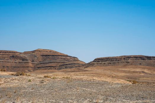 A view from the crater in the Ramon Crater. Arid desert view. White sands and a horizon of blue skies. Negev, Israel. High quality photo