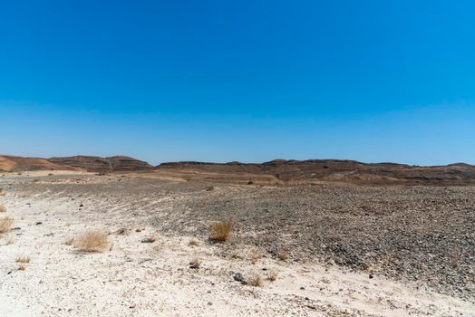 A view from the crater in the Ramon Crater. Arid desert view. White sands and a horizon of blue skies. Negev, Israel. High quality photo