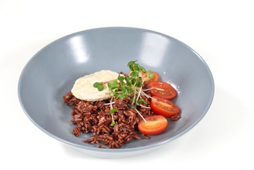 Close up of blue large plate with brown rice, tomatoes, greens and diet bread. Concept of delicious food with good composition and healthy food for emaciation or support body. 