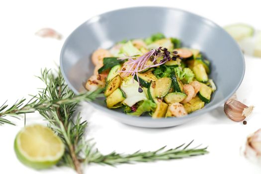 Close up of appetizing salad with tasty juicy shrimps and zucchini,garlic on white background. Concept of proper nutrition to lose weight or maintain body weight. 