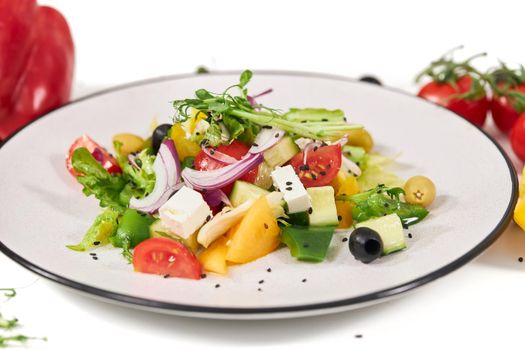 Close up of large white plate vegetables salad with tomatoes,onion,peppers,olives and greens. Concept of fresh salad with vitamins for weight maintenance and weight loss. 