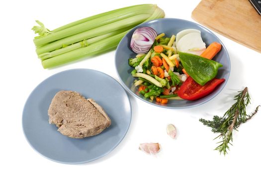 Top view of delicious boiled meat and different vegetables on table for tasty dish. Concept of cooking yummy meal with healthy ingredients garlic,rosemary,celery,colorful vegetables. 