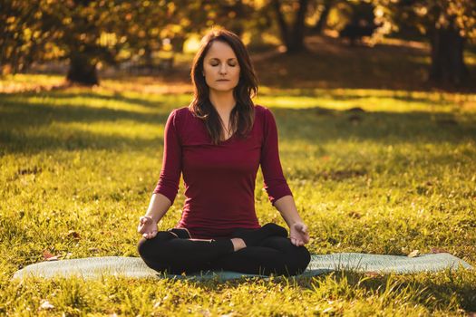 Beautiful woman sitting in lotus position and meditating in the nature,Padmasana/Lotus position.