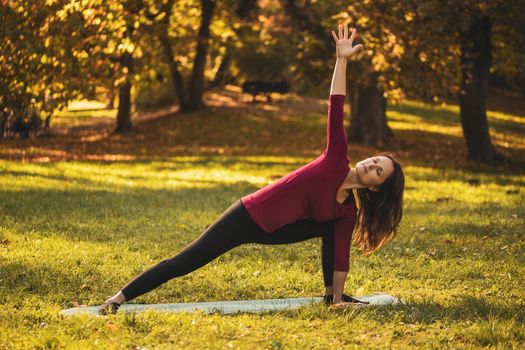 Beautiful woman doing yoga in the nature,Trikonasana/Triangle pose