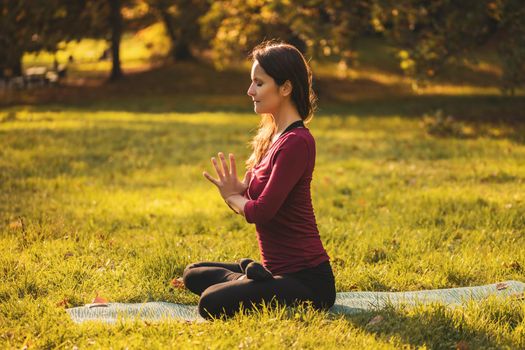 Beautiful woman sitting in lotus position and meditating in the nature,Padmasana/Lotus position.