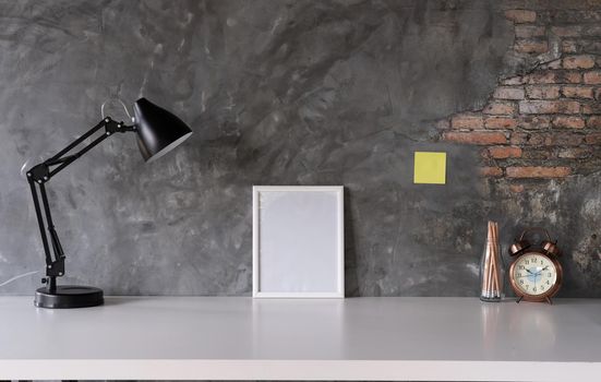White desk with photo frame, lamp, office supplies, clock in design vase.