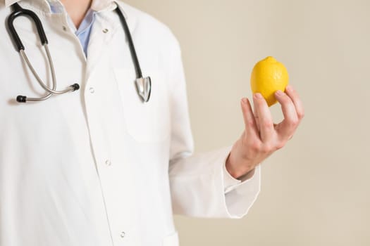 Image of male doctor holding lemon.
