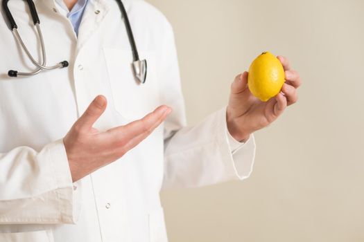 Image of male doctor holding lemon.