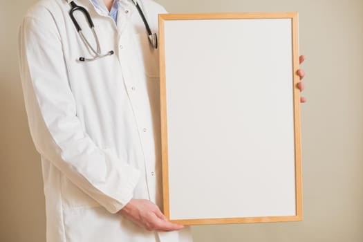 Image of male  doctor holding white board.