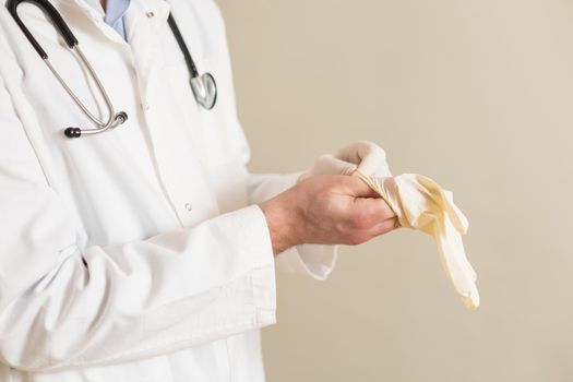 Image of male doctor putting on protective gloves.