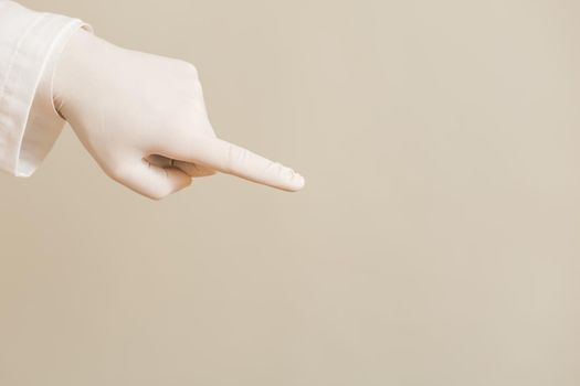 Image of close up hand in protective glove  of doctor pointing.