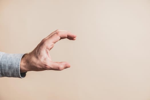 Close up image of male hand in holding gesture.