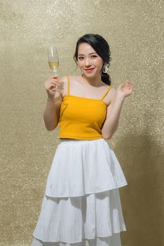 One young and beautiful woman dancing with glass of champagne and smiling. Party concept