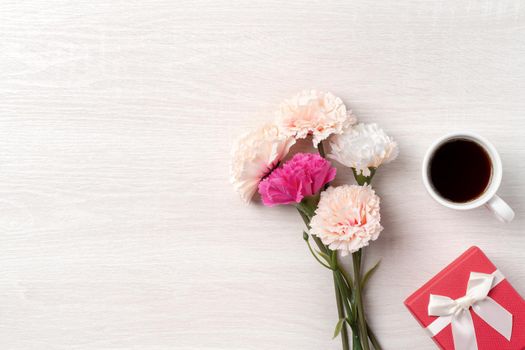 Mother's Day design concept. Top view of beautiful carnation flower and holiday gift idea with copy space.