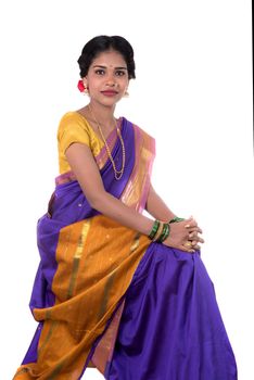 Beautiful Indian young girl posing in traditional Indian saree on white background.