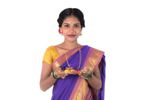 Indian woman performing worship, portrait of a beautiful young lady with pooja thali isolated on white background