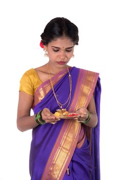 Indian woman performing worship, portrait of a beautiful young lady with pooja thali isolated on white background