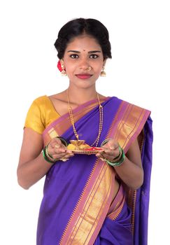 Indian woman performing worship, portrait of a beautiful young lady with pooja thali isolated on white background